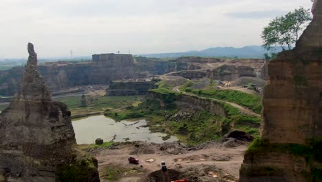 Aerial-view-of-open-pit-Brown-Canyon-sand-mine-between-to-rock-cliffs-Indonesia