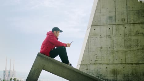 Junger-Attraktiver-Trendiger-Junger-Mann,-Der-Mit-Einem-Handy-Auf-Einem-Städtischen-Stadthintergrund-Anruft-Und-Mitteilt