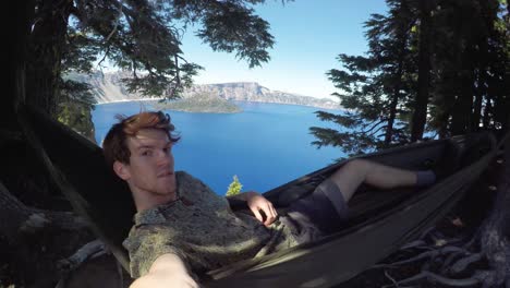 young attractive man selfie swinging in a hammock