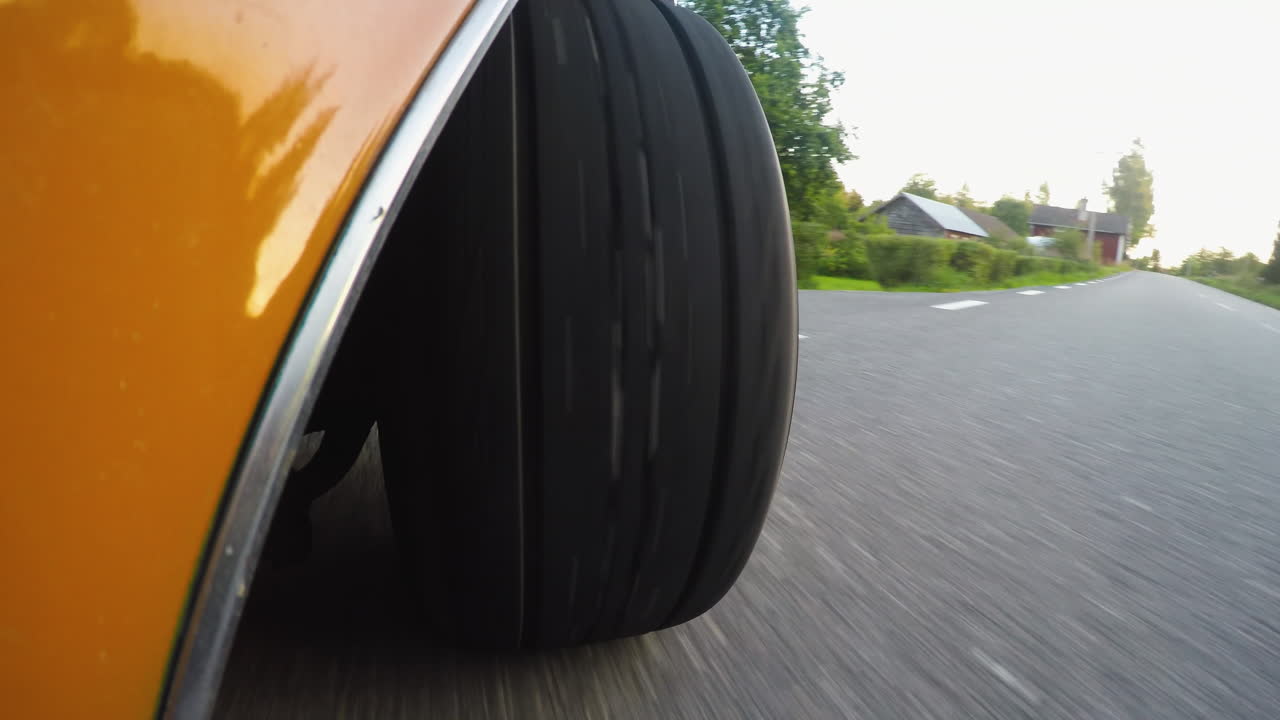 primer plano de 4k desde el lado de una rueda de coche retro mientras conduce por una carretera
