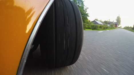 4k close-up from the side of a retro car wheel while driving on a road