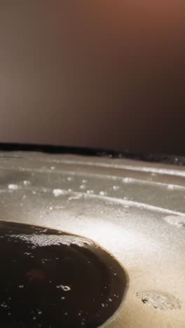 loudspeaker with soapy water in apartment. white coke powder falls onto dynamic diaphragm and transparent liquid ripples. music and illegal substances macro