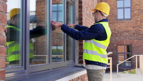 Männlicher-Baumeister-Mit-Lineal-Und-Klemmbrett,-Das-Fenster-Misst.-Baugeschäft-Und-Gebäudekonzept