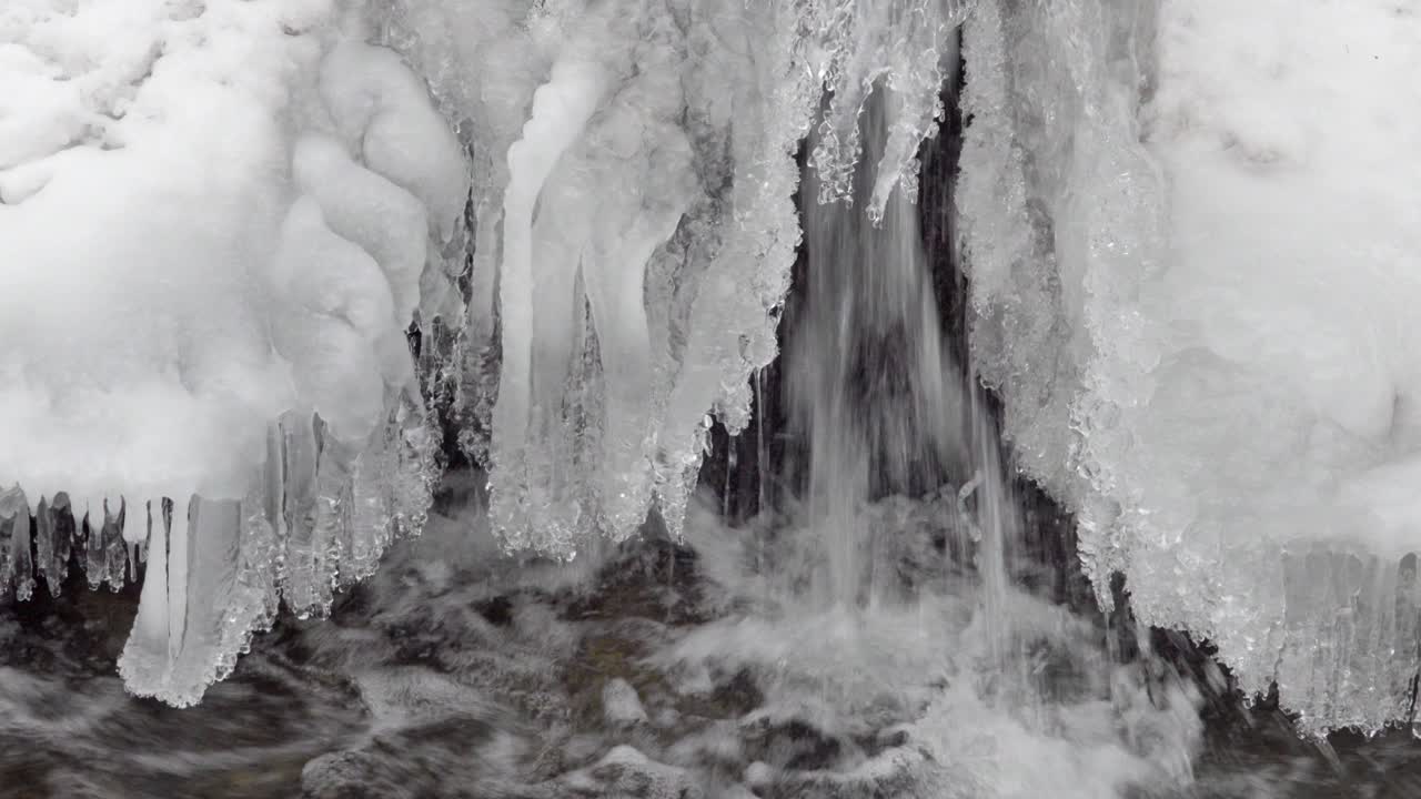 este es un primer plano del agua que fluye bajo una cubierta de hielo en un arroyo en invierno
