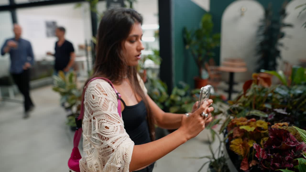 Woman taking pictures of plants indoors