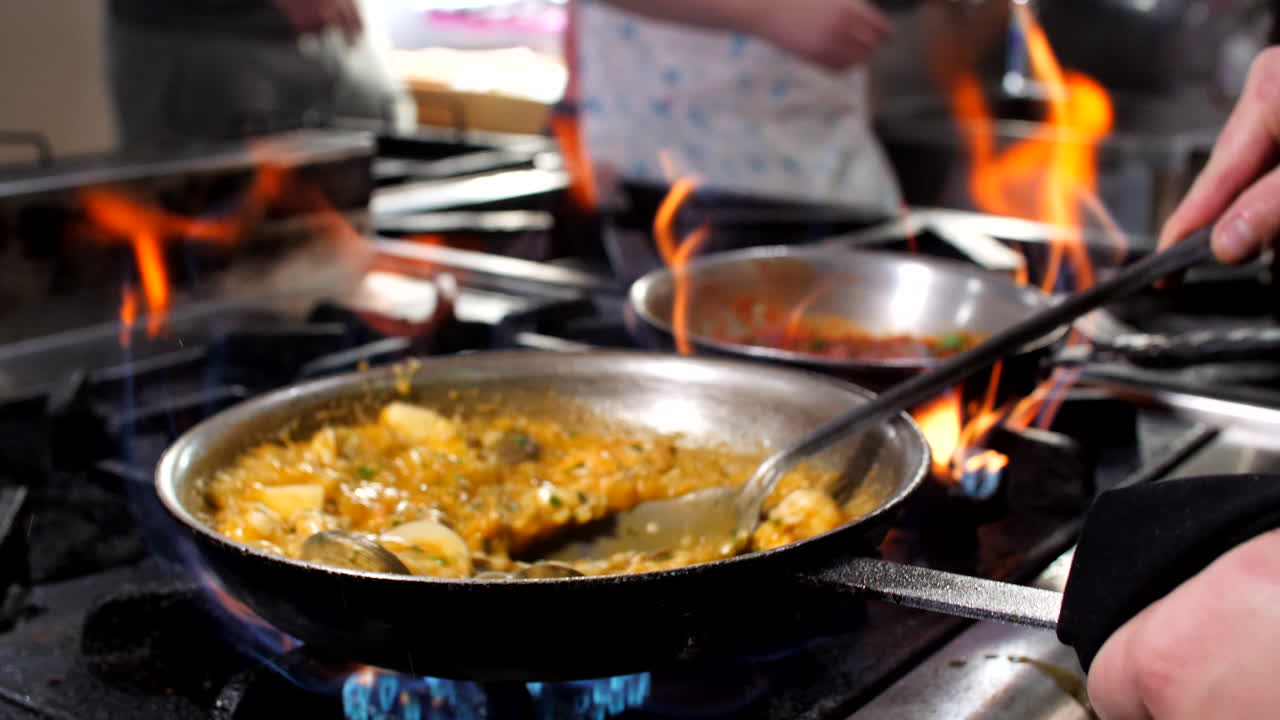 Chef preparing seafood risotto in restaurant, close-up, Mediterranean