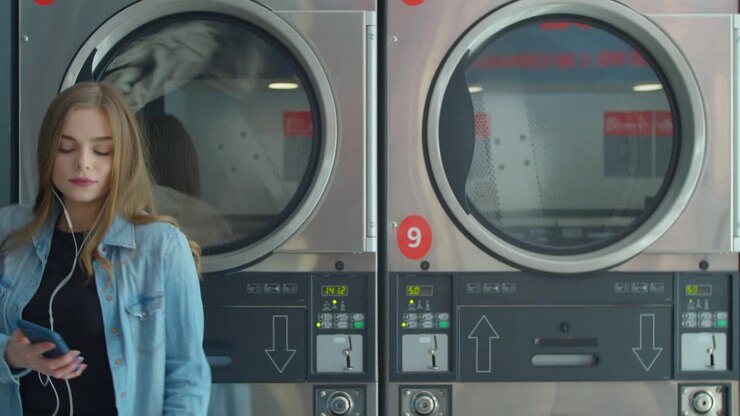Portrait of woman dancing in the self-service public laundry.