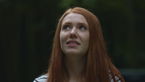 a happy blonde woman with long hair looking up and turning his head and eye around with a smile