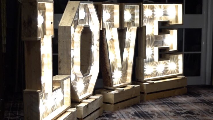 Lettere nuziali con luci bianche che formano la parola 'Love' come decorazione.