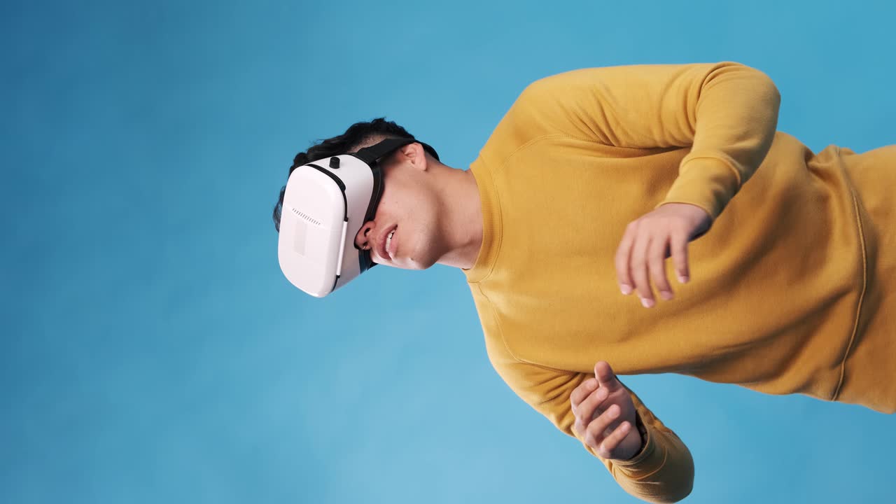 Man with VR headset enjoying experiencing virtual reality while standing on an isolated background.