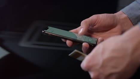 man hand holding credit card and using smartphone for online payment