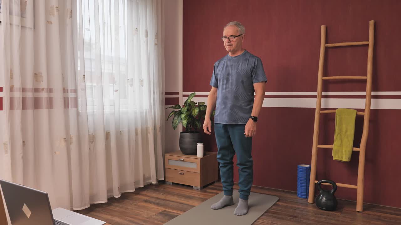 Uomo maturo che si allena in casa, routine di fitness domestico per rimanere in forma e forte, stile di vita sano per adulti più anziani