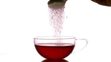 sugar pouring into cup of tea