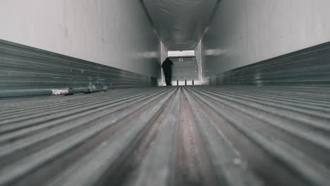 truck driver doing an inspection inside of a emty reefer trailer