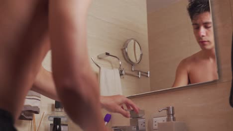 man washing his face in front of her bathroom mirror