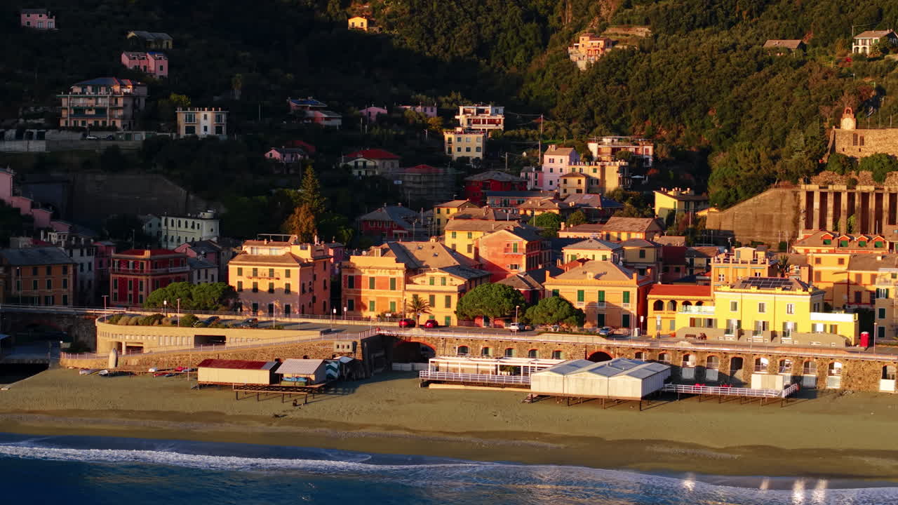 Vista drone dal mare della costa di Bonassola con edifici illuminati dal sole al tramonto