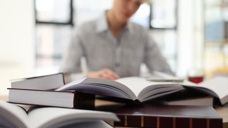 a person studying surrounded by books