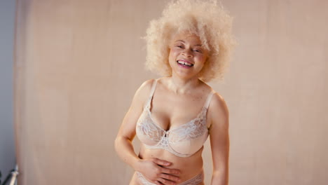 retrato de estudio de una mujer albina natural y segura en ropa interior que promueve la positividad corporal