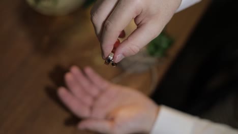 El-Novio-Con-Camisa-Blanca-Deja-Caer-Los-Anillos-De-Boda-En-La-Palma-De-Su-Mano.-El-Hombre-Toca-Los-Anillos.