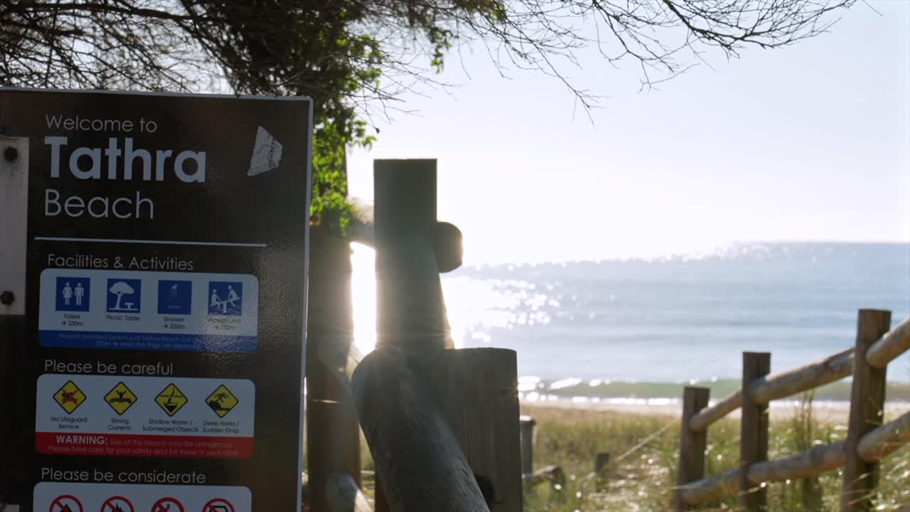 Placa da Praia de Tathra com o oceano e a luz do sol refletindo na água, Tathra, Nova Gales do Sul, Austrália.
