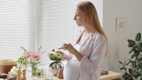 pregnant woman eating a healthy salad