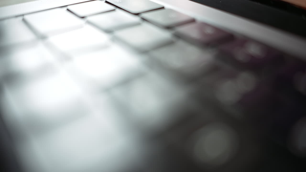 Laptop keyboard close-up, blurred details, on a sunny day