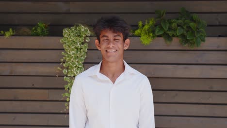 Young-and-handsome-male-fashion-model-posing-with-wooden-background