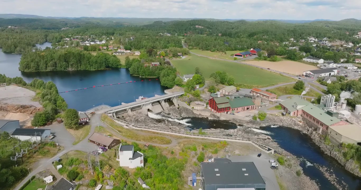 Luftaufnahme des Wasserkraftwerks und Staudamms Rykene in Finnland in Zeitlupe, die nordische Landschaft zeigend.