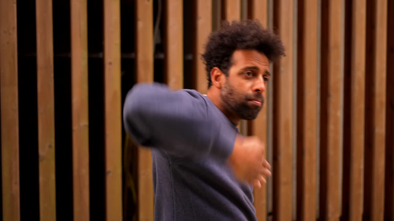 A man standing in front of a wooden fence
