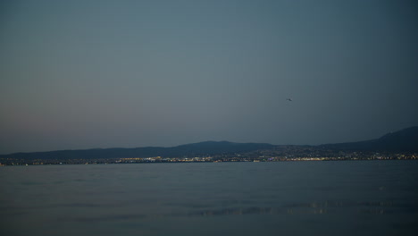 serene evening with distant airplane over calm waters