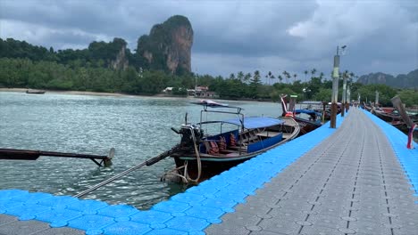 arrival at boat dock in railay, rocks, palm trees, motor boats