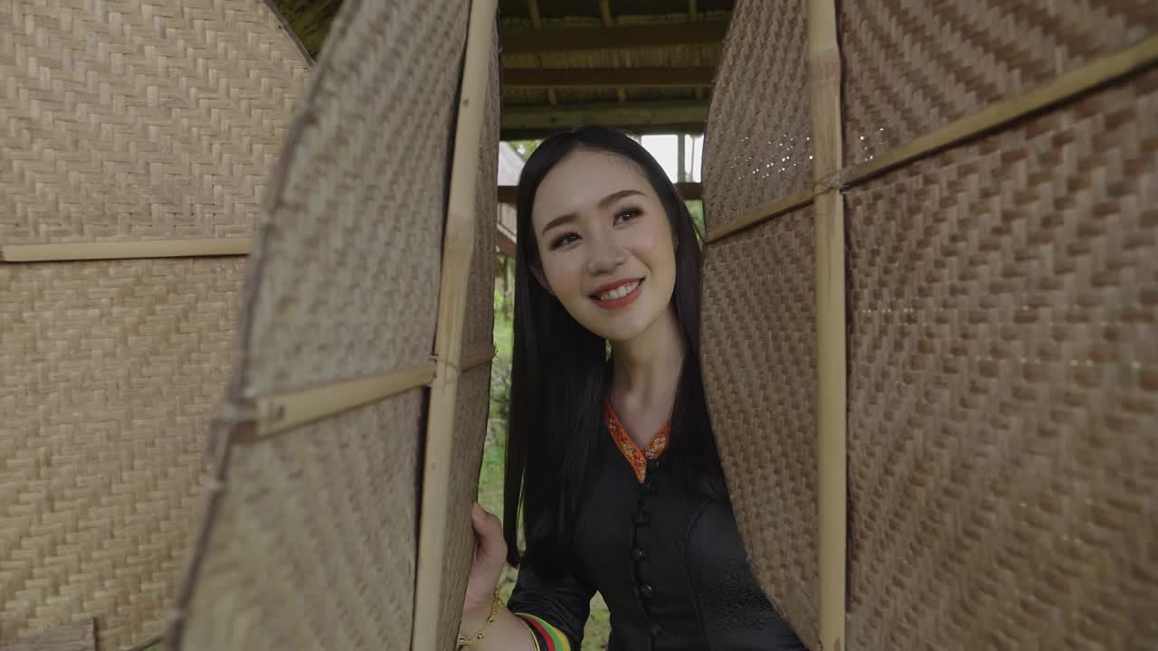 Asian Woman in Traditional Dress in a Bamboo Hut