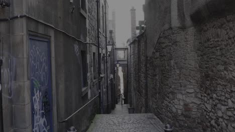 a close-alley on the royal mile in edinburgh with graffiti on the walls