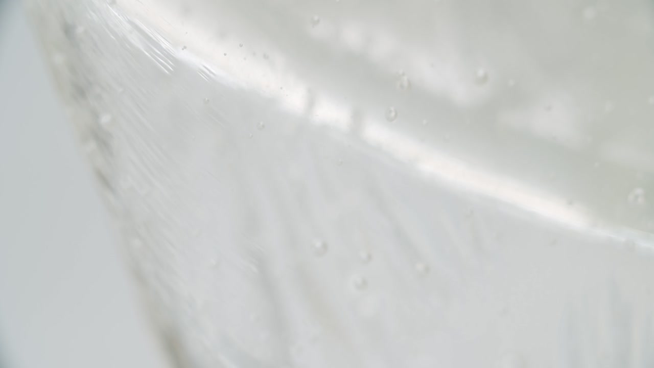 프레임 밖의 유리 구조에서 작은 기포가 떨어지는 흰색 투명한 액체