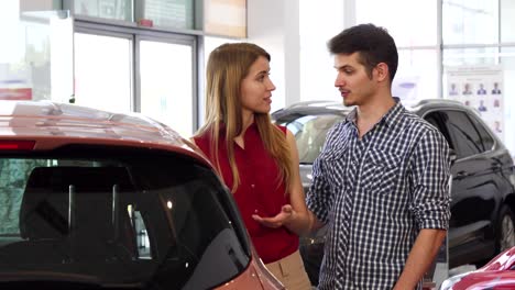 beautiful couple examining new automobile at the dealership