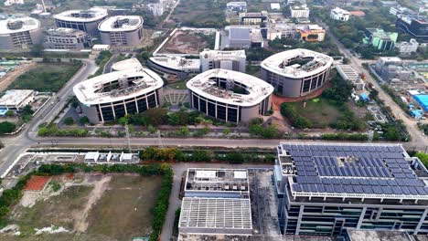 an expansive aerial shot captures a sprawling, modern technology park or corporate campus bathed in the warm glow of a setting or rising sun. the sky is hazy