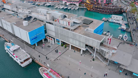 top view of people walking on pier at porto antico - view of genoa aquarium