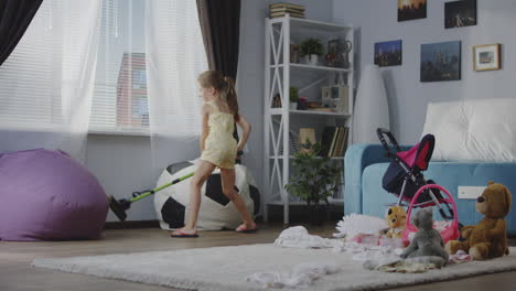 little girl cleaning up toys in the living room