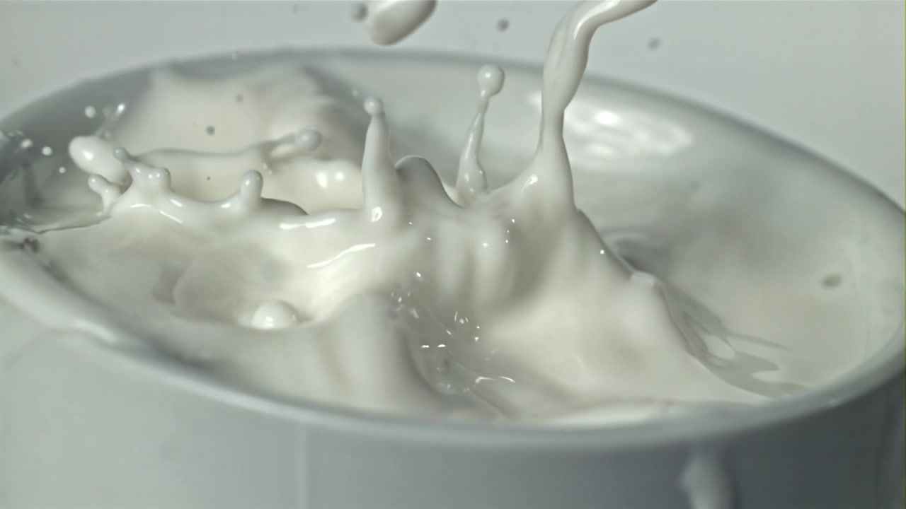 白いボウルの中で牛乳のしずくがスローモーションではねる。