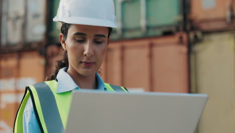 female engineer working on laptop at container port