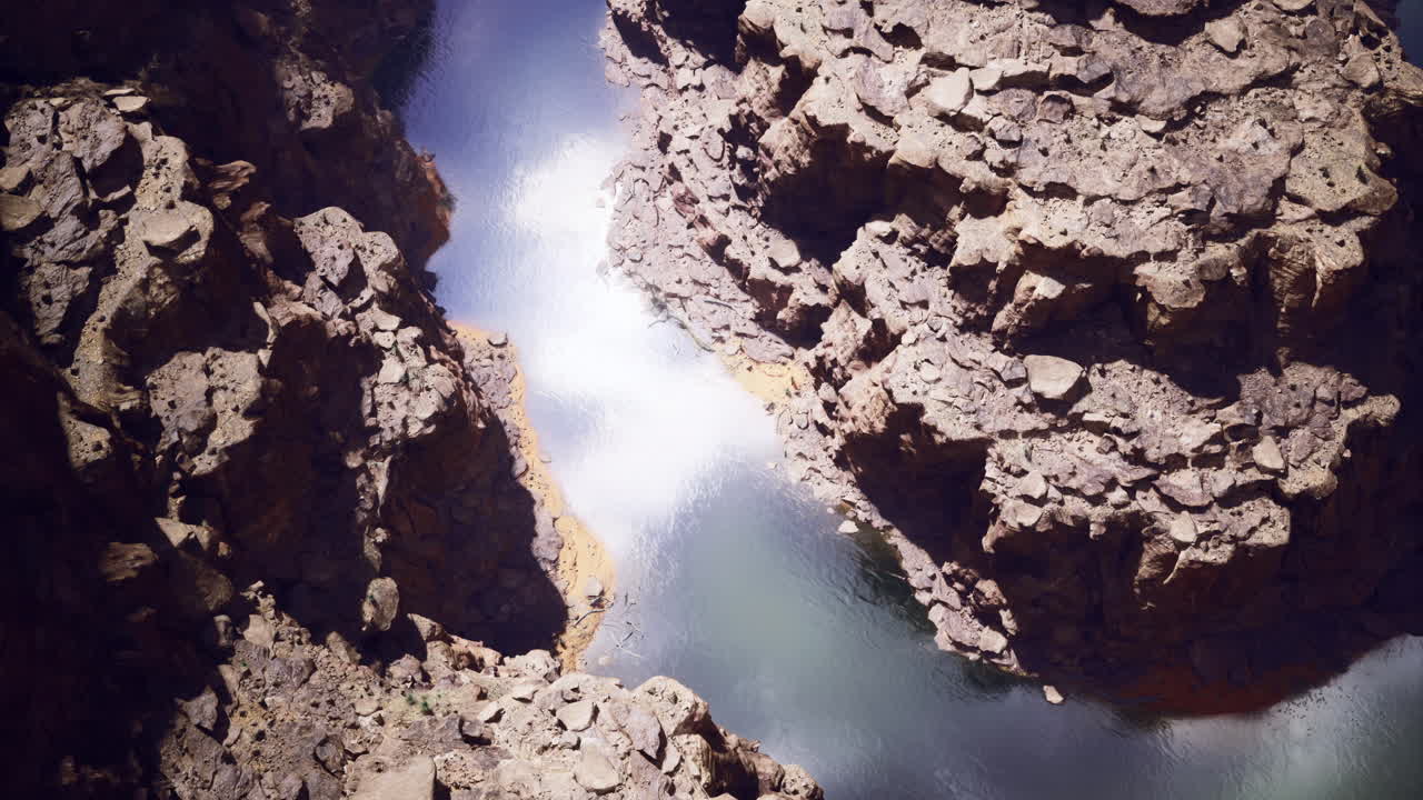 Water flows through rocky canyon during bright daylight at scenic location