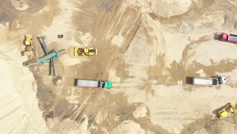 Aerial-view-loading-bulldozer-in-open-air-quarry