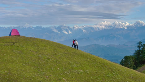 Drone shot captures couple in Nepal enjoying romantic morning escape to nature Hiking on mountain ranges camping under blue sky embrace refreshing beauty of landscape