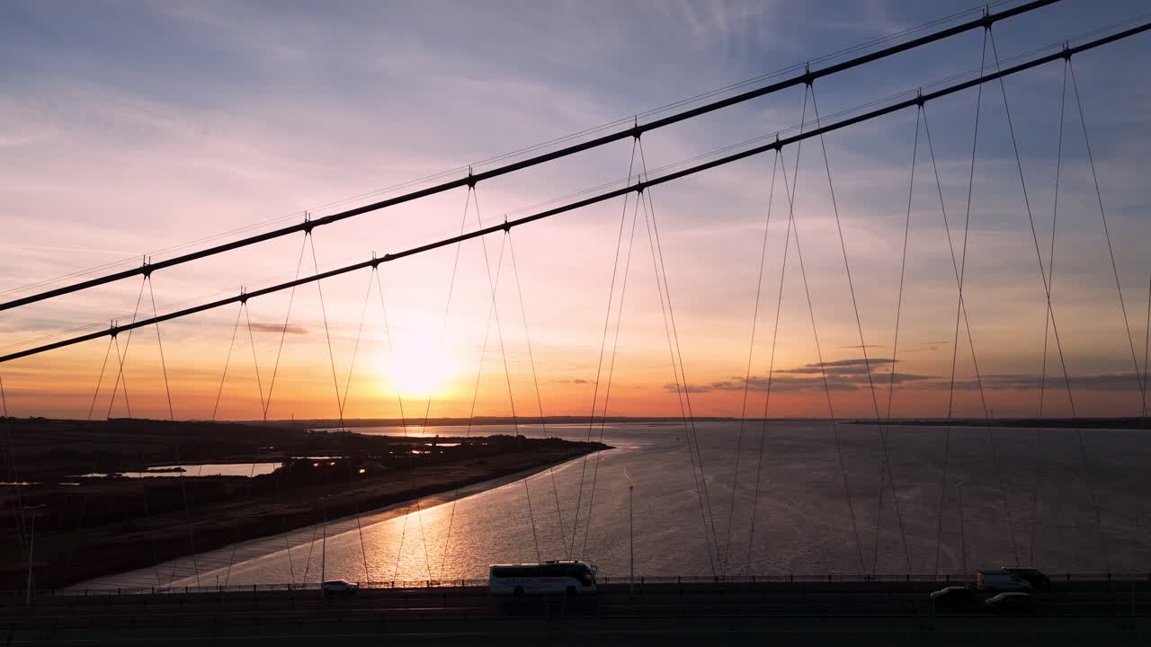 Serenity in motion: Aerial view of the Humber Bridge and cars traversing it at the sun's edge