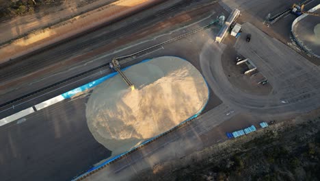 un camión de grano siendo descargado a través de tuberías en un enorme silo en australia occidental