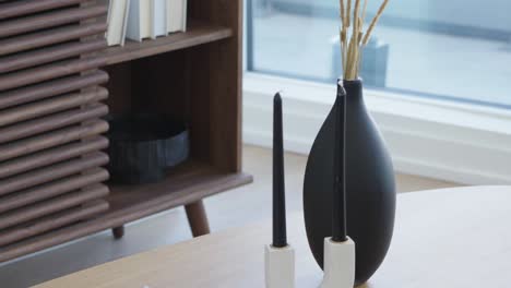 detail tilt shot of the coffee table with book and candle on it in the living area in a high ceiling penthouse condominium unit during a sunny day