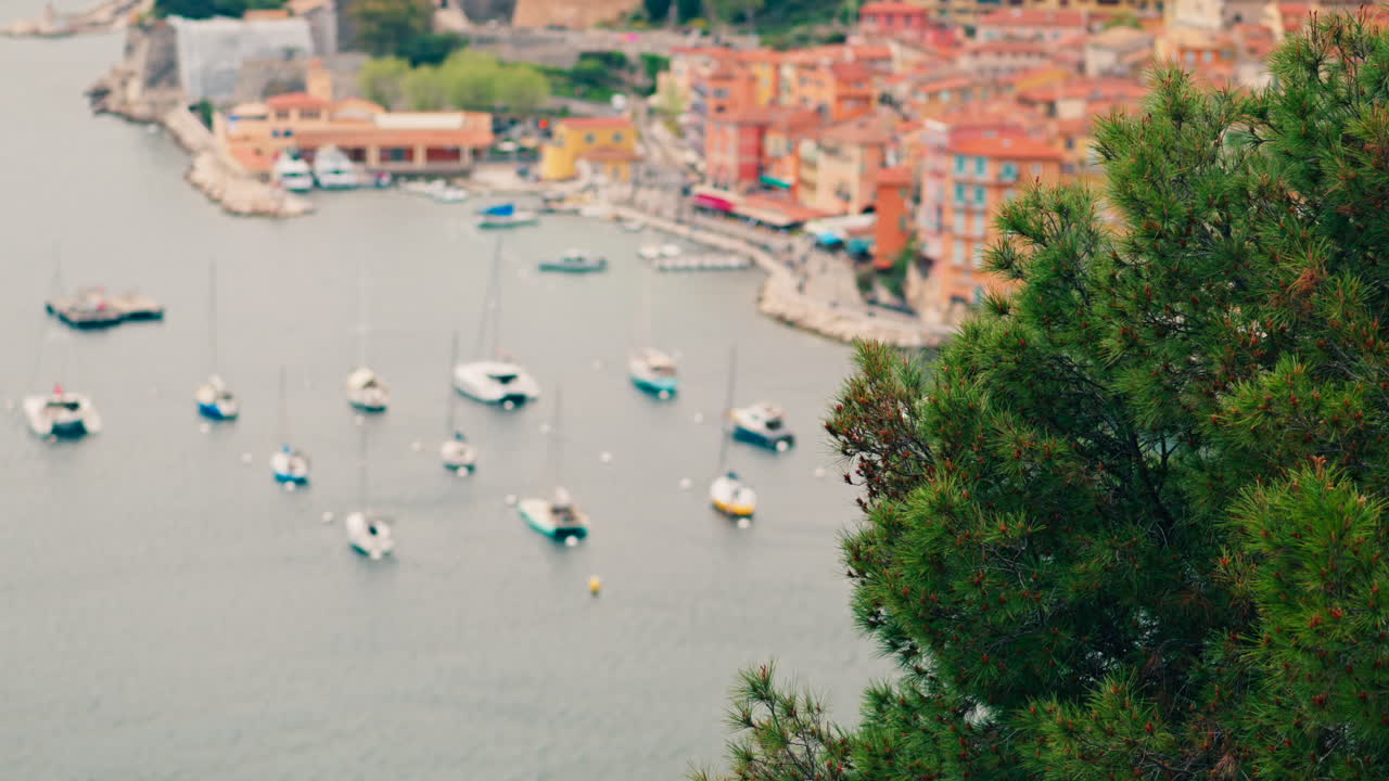View of the colourful buildings of Villefranche sur Mer, France on the coast with small boats docked on the sea