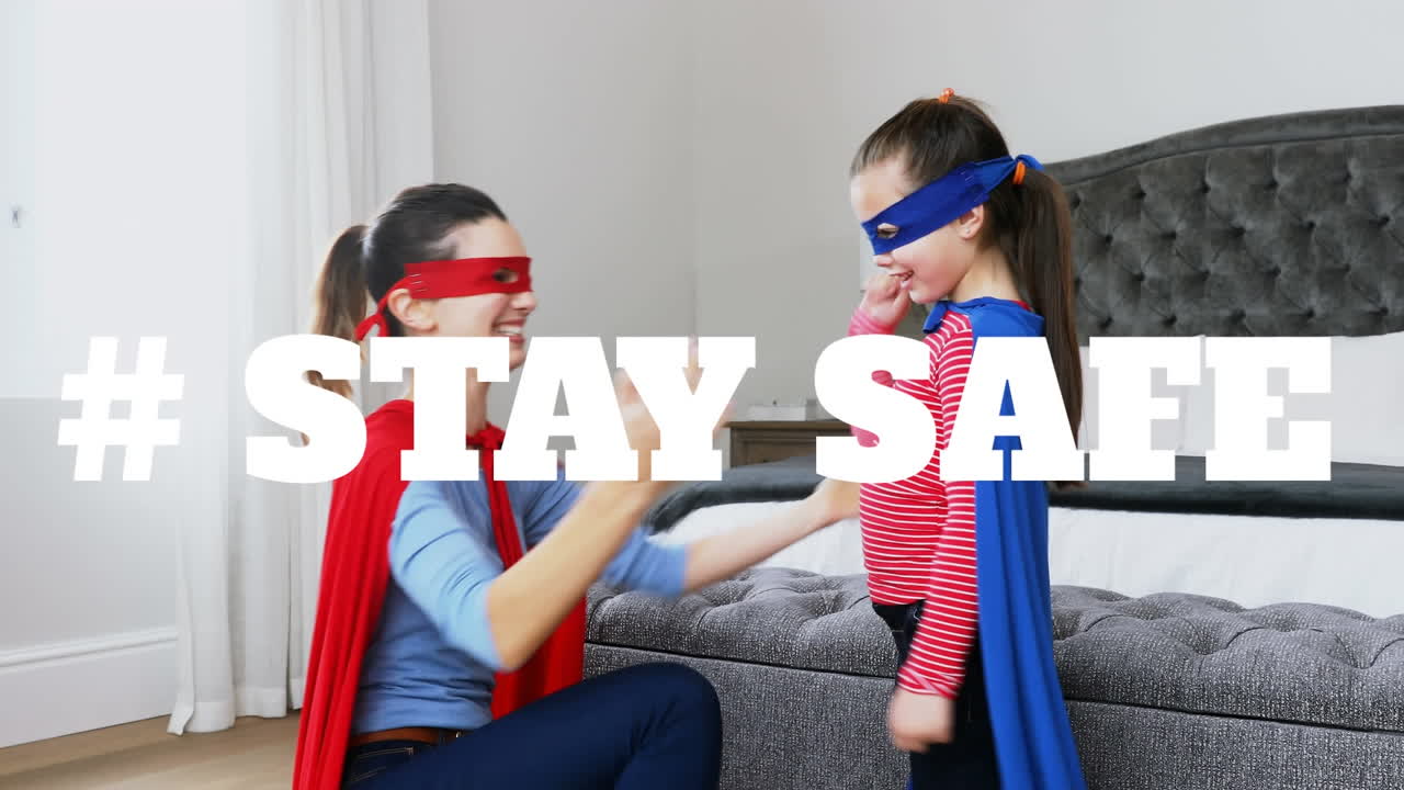 코로나바이러스 전염병 기간 동안 안전하게 지내라는 단어가 새겨진 케이프를 입은 백인 여성과 딸