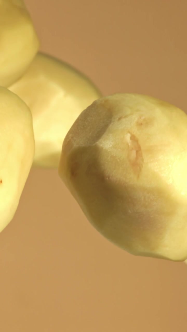 Primo piano di patate fresche pelate che ruotano lentamente.