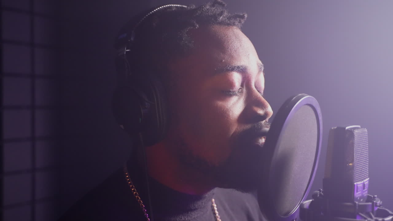 Man Singing Into Microphone in Recording Studio